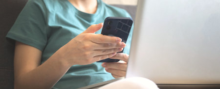 Banner pretty yong girl using mobile phone and laptop indoors, cozy autumn background photo