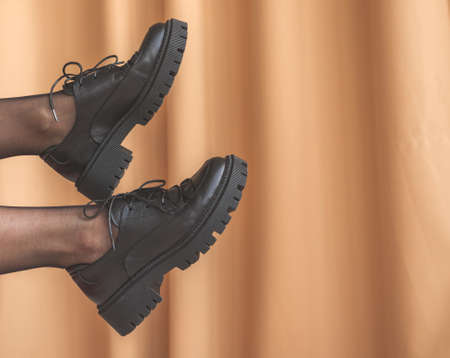 Woman legs in black pantyhose and black shoes in modern interior background. Concept of elegant and glamor young woman photoの写真素材