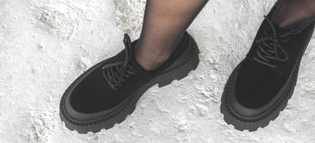 Black boots on woman legs, urban fashion concept, banner background