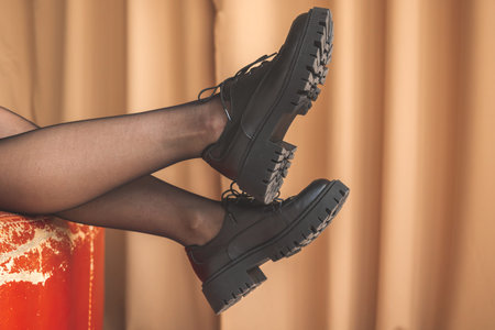 Elegant woman legs on old red chair in modern interior room. Concept of glamor and sexy beautyの写真素材