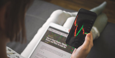 Stock market trading from home. Businesswoman with mobile phone cheking stock market chart price,...