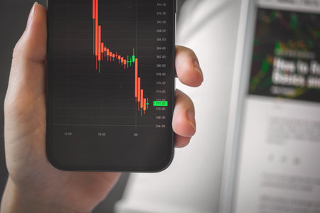 Person engaged in stock trading. Business and investement background photo. Smartphone with...