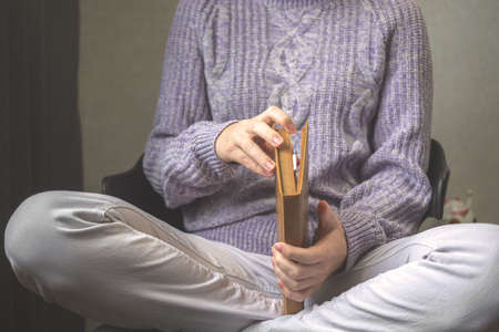 Woman relaxing and reading book on cozy bed in log cabin in winter. High quality photoの写真素材