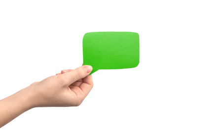 Green speech bubble in hand isolated on a white background. Giving feedback, communication concept...
