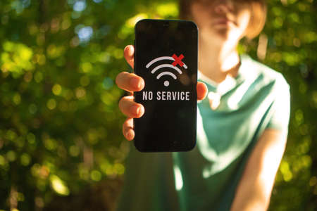 Can not find any mobile phone coverage Girl lost in the woods, mobile phone no signal screen, searching for the help, communication in the forest photoの写真素材