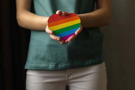 Woman holding rainbow heart in hands, LGBT, lesbian and gay, tolerance concept backgroundの写真素材