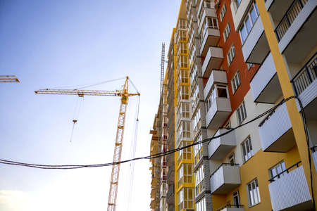 Construction site and yellow construction tower crane. Construction machinery and modern technology, building businessの写真素材
