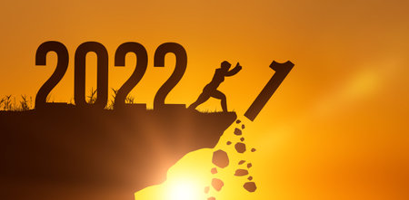 Man pushed of the 2021 to new year 2022 on sunset sky background. New year new normal concept photo