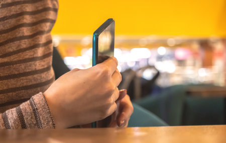 Woman hide the mobile phone in pocket in cafe. Coffee break is over, time is out conceptの写真素材