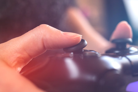Gamer playing game by joystick, concept of streaming online, gaming and esports challenge. Closeup to hands with gamepad controllerの写真素材