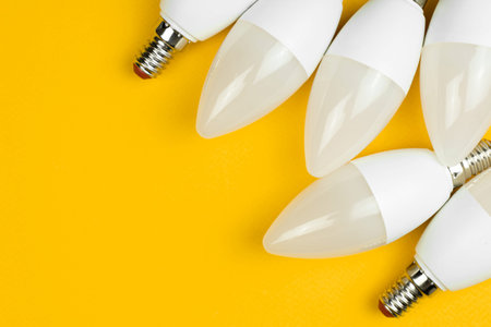 Home LED light bulbs, yellow background. Energy-saving and eco friendly light bulbs. Flat lay, top...