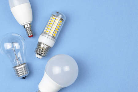Old and new bulbs together, pastel blue background. Energy saving concept. Flat lay, top viewの写真素材