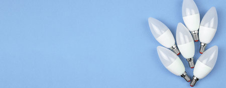 Eco friendly LED light bulbs, pastel blue background. Energy saving concept. Banner flat lay, top...