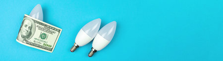 Energy efficiency concept. LED light bulb and dollar money bill. Saving energy wide banner with copy...