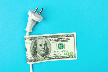 Electricity costs. Electrical power cable and money, dollar bills. Energy savings, energy efficiency conceptの写真素材