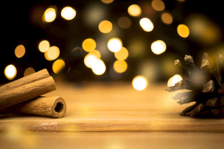 Empty wooden table with christmas lights and cinnamons. Happy new year and holiday concept. Blank space for montage product placement display photoの写真素材