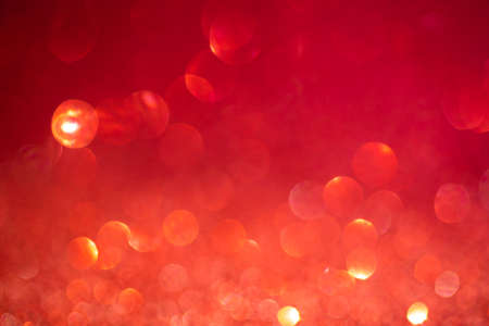Red bokeh background. Vintage glitter lights, glowing christmas effects backdrop photoの写真素材