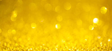 Gold lights background, banner design. Shiny glowing surface with bokeh, abstract defocused glitter with a sparklesの写真素材