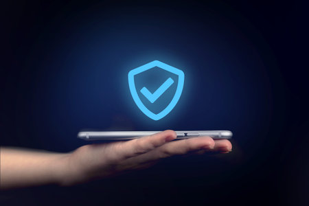 Data protection, privacy information. Hand holding mobile phone with shield. Cyber security network,...