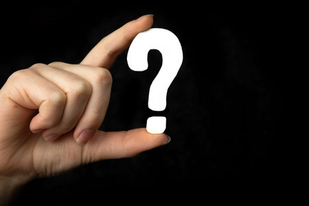 Question mark sign in hand. Question icon, symbol on a black background. Concept of doubt, education...