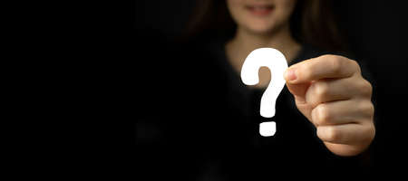 Question mark sign in woman hand. Question icon, symbol on a black background. Concept of doubt, education or FAQ photoの写真素材