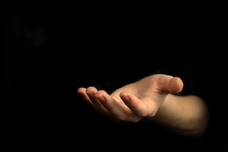 Giving hand gesture, empty woman hand on a black backgroundの写真素材