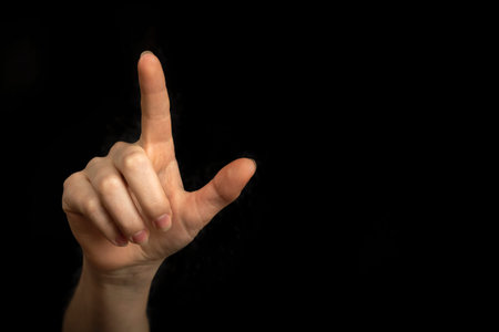 Businesswoman hand pointing on empty space on a black background