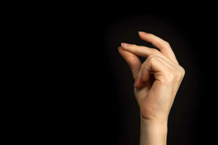 Hand gesture snapping fingers, easy sign and symbol on a black background photoの写真素材