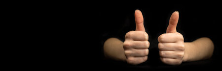 Business gesture. Thumb up close-up. Banner, black background with copy space photoの写真素材