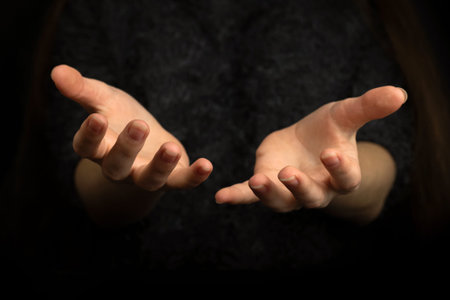 Praying gesture with hands on a black backgroundの写真素材