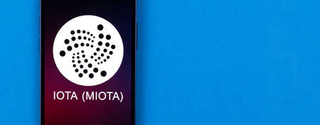 MIOTA symbol. Trade with cryptocurrency, digital and virtual money, banking with mobile phone concept. Business workspace, banner, table top viewの写真素材