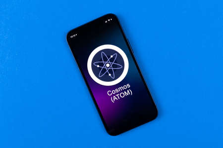 Cosmos ATOM symbol. Trade with cryptocurrency, digital and virtual money, banking with mobile phone concept. Business workspace, table top viewのeditorial素材