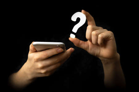 Mobile phone and FAQ symbol. Technology, information, service concept. Support. Black backgroundの写真素材