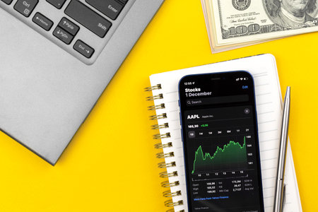 Kharkov, Ukraine - December 1, 2021: Apple AAPL stock trade with mobile phone. Business desktop, investment online photoのeditorial素材