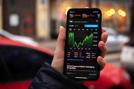 Kharkov, Ukraine - December 1, 2021: Toyota TM stock trade. Financial graphs, investment, digital banking concept photo. Smartphone with stock market app in handのeditorial素材