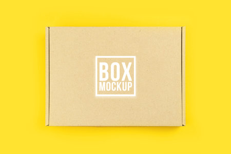Cardboard box mockup, shipping and delivery concept. Yellow table background photo. Suitable for...