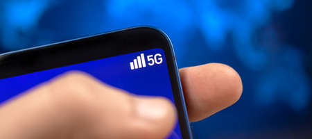 Man uses mobile phone with 5G network wireless system. Banner photo, concept of high speed mobile internet, new generation networksの写真素材