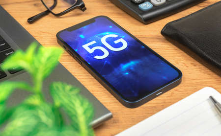 Phone with 5G network, hologram background. Business desktop. Concept of high speed internet, new generation of networksの写真素材