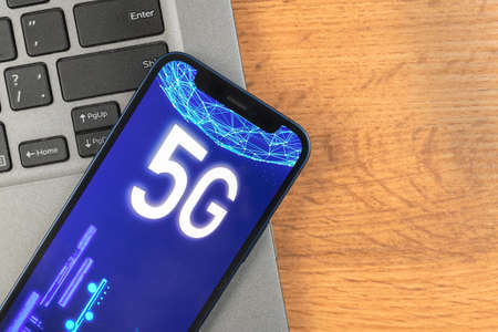 Phone with 5G network. Business desktop background. Concept photo of high speed internet, new generation of networks, data and connection, hologram on the screen closeupの写真素材