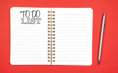To do list concept. Planning for new year. Red background, silver pen, copy space and top viewの写真素材