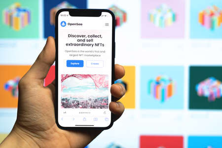 Kharkov, Ukraine - December 17, 2021: Man uses OpenSea marketplace for NFT selling. Website with closeup on mobile phone screen. Concept of cryptoart, digital arts and collectiblesのeditorial素材