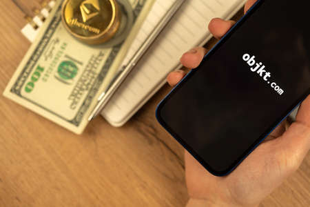 Kharkov, Ukraine - December 20, 2021: Person uses Objkt.com NFT marketplace website, on mobile phone screen closeupのeditorial素材