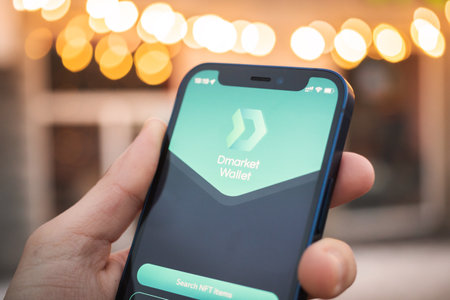 Kharkov, Ukraine - December 25, 2021: Person uses Dmarket Wallet app on Apple iPhone 12. Title screen close-up, crypto and NFT conceptのeditorial素材