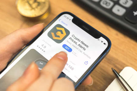 Kharkov, Ukraine - January 10, 2022: Crypto News app icon closeup. Woman with application on Apple iPhone 12のeditorial素材