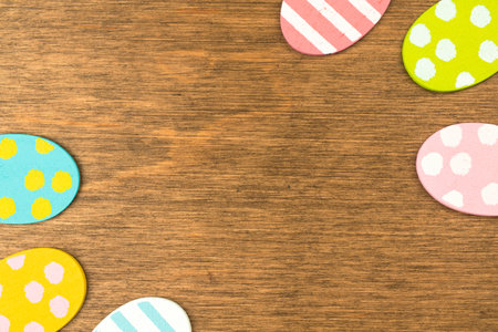 Colorful Easter eggs double side border, old rustic wood background, flat lay design, top view with...