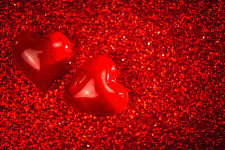Valentines day background, two red hearts on red glitter background. copy spaceの写真素材