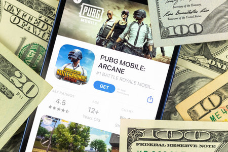 Kharkov, Ukraine - January 19, 2022: PUBG mobile game app and money background photo