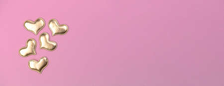 Valentine day greeting banner concept with golden heart decoration on bright pink background top view, copy space. flat layの写真素材