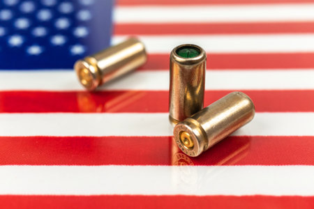 USA outlaw, ghetto, social problem and armed attack background. Gun bullets over the American flag photoの写真素材