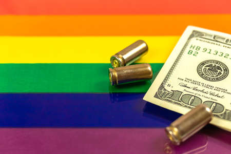 Pride rights flag with money and gun bullets. Criminal love background photoの写真素材